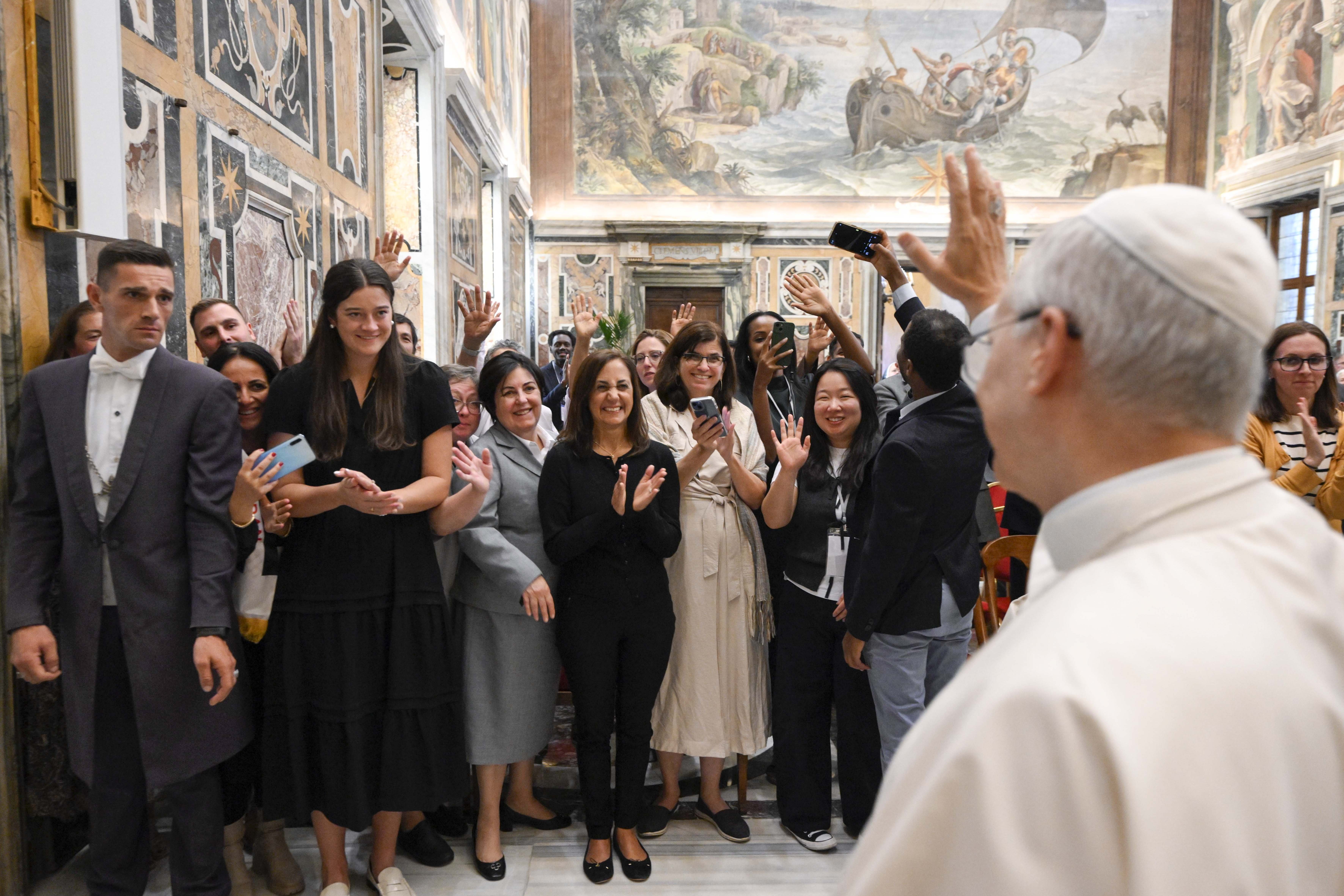 Pope Leo XIV waves to participants at migration conference