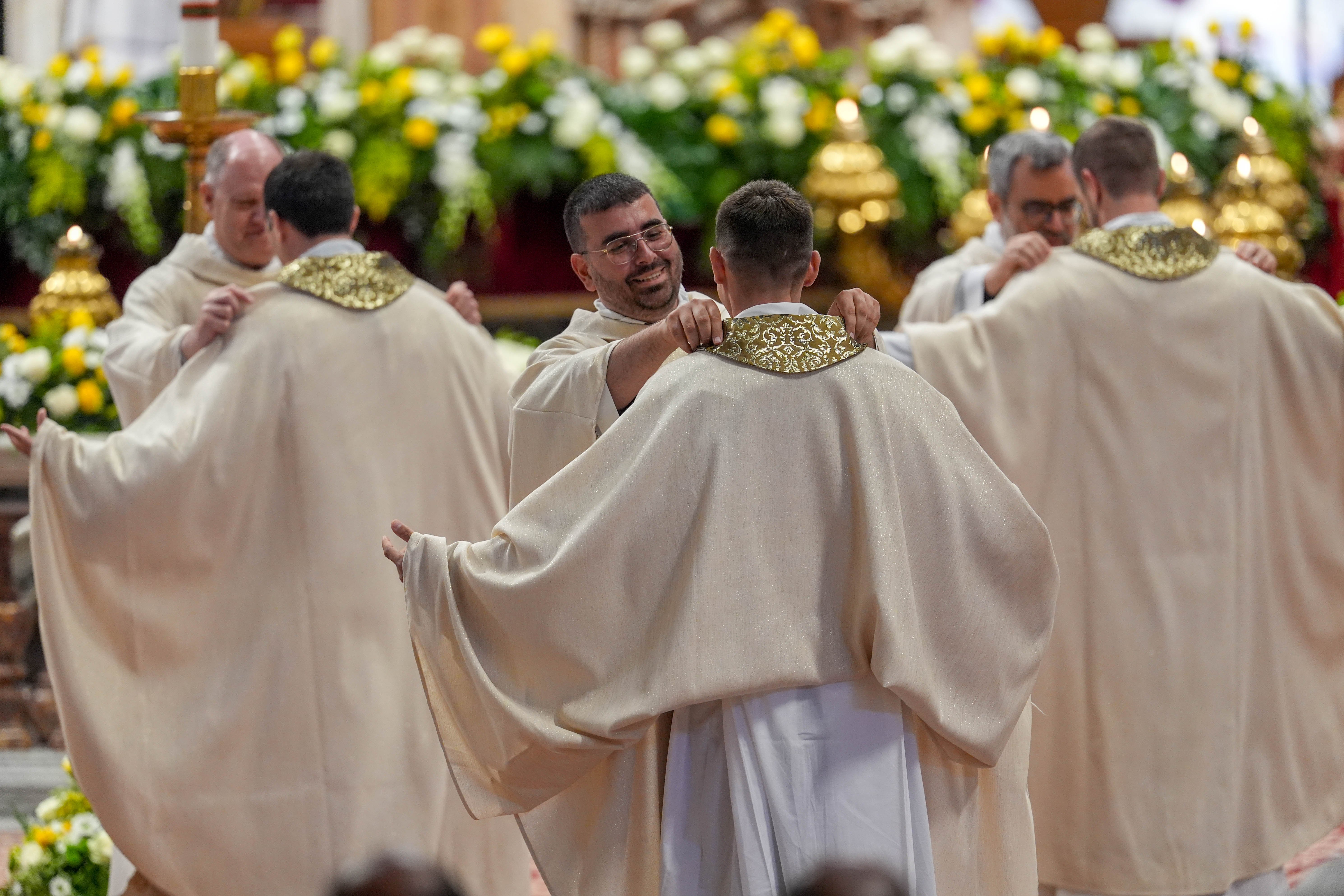 Priests help newly ordained priests with their vestments
