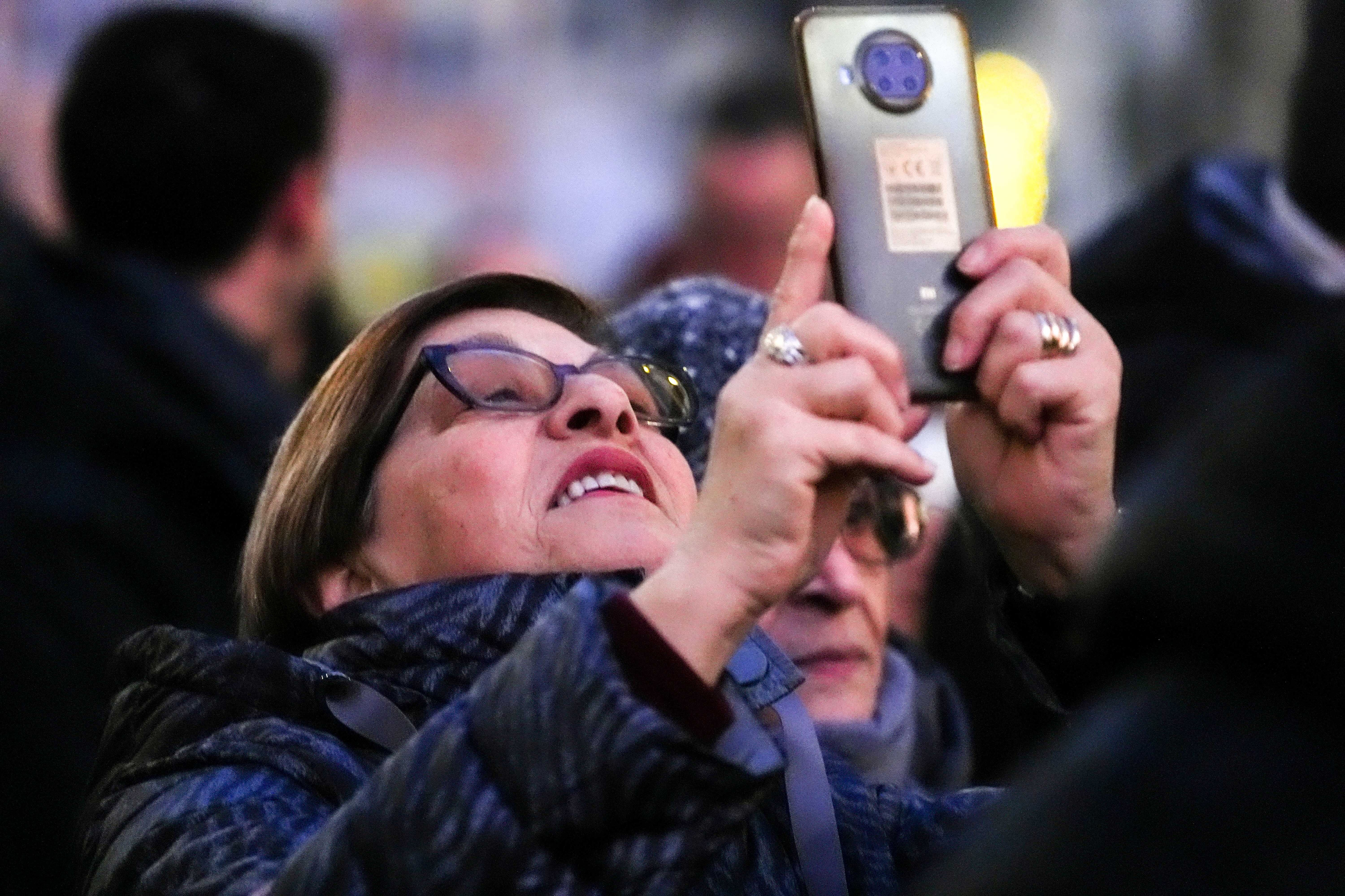 A woman takes a photo of the statue of the Immaculate Conception