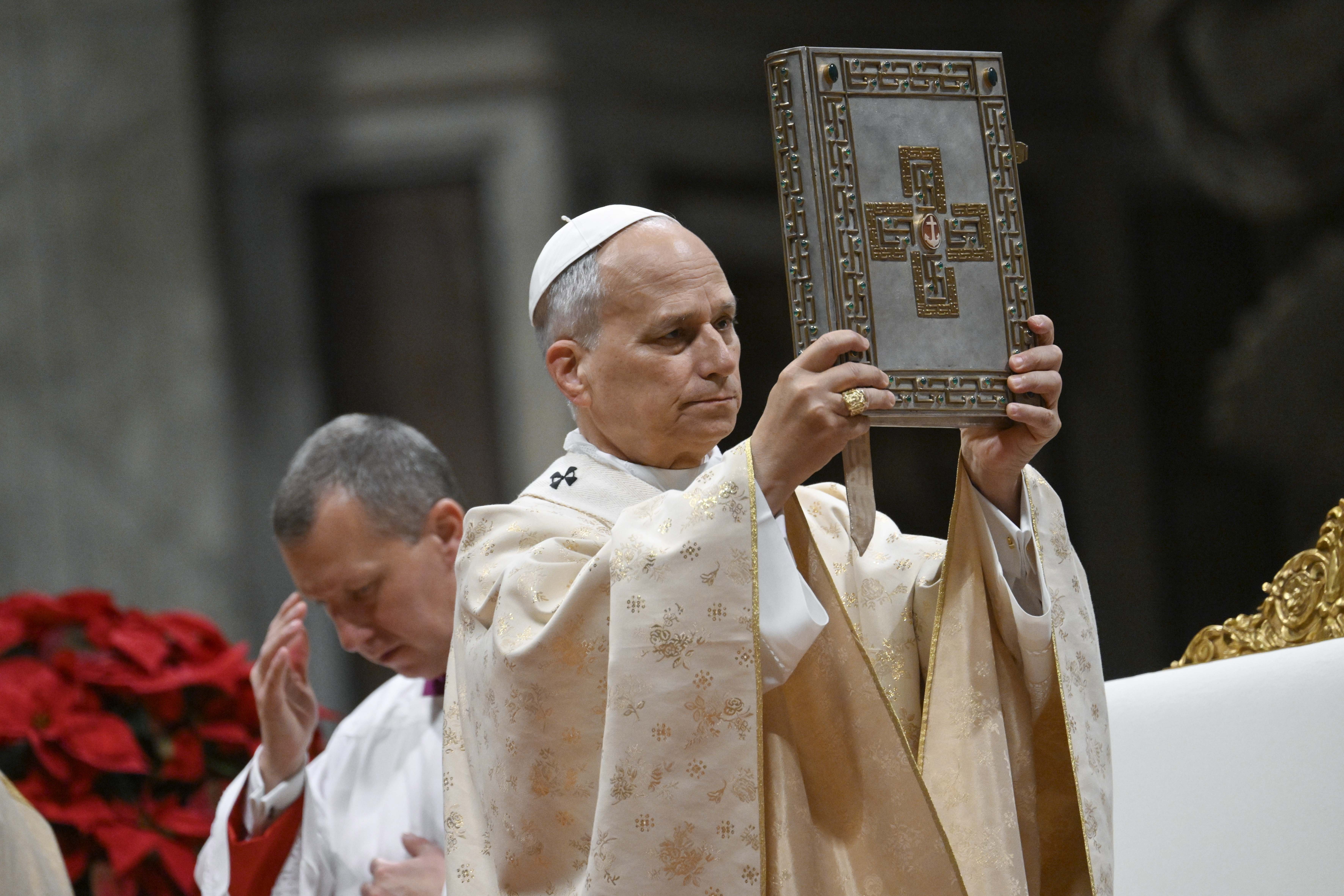 Pope Leo blesses people with the Book of the Gospels
