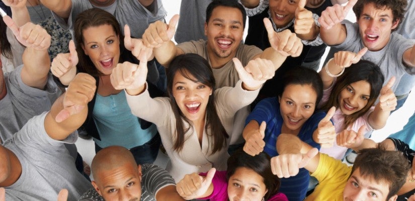 a multicultural crowd of people cheering