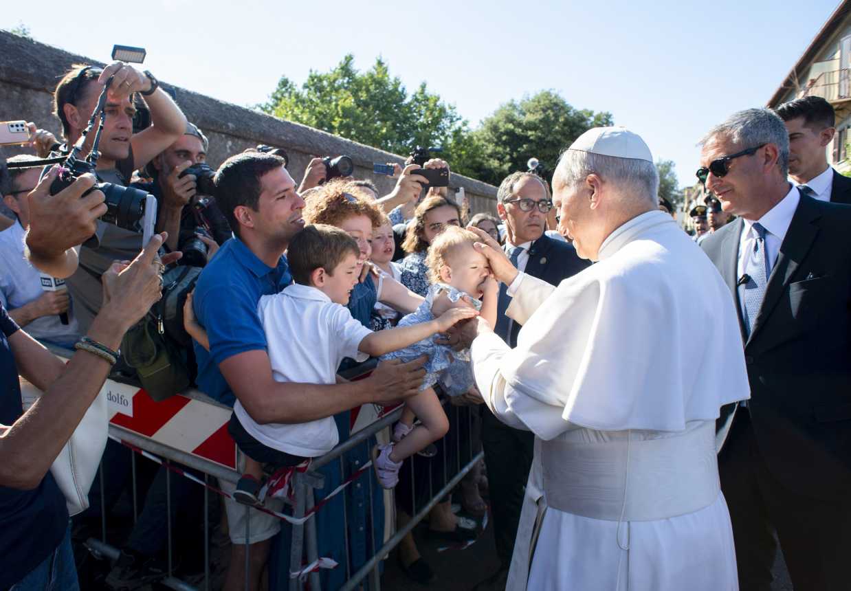 Pope Leo XIV greets children as he arrives in Castel Gandolfo, Italy.