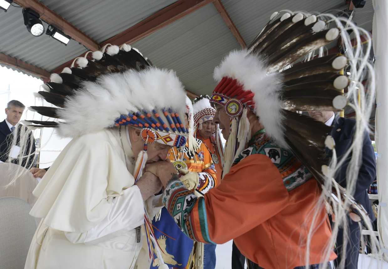 Pope Francis kisses the hand of an Indigenous leader