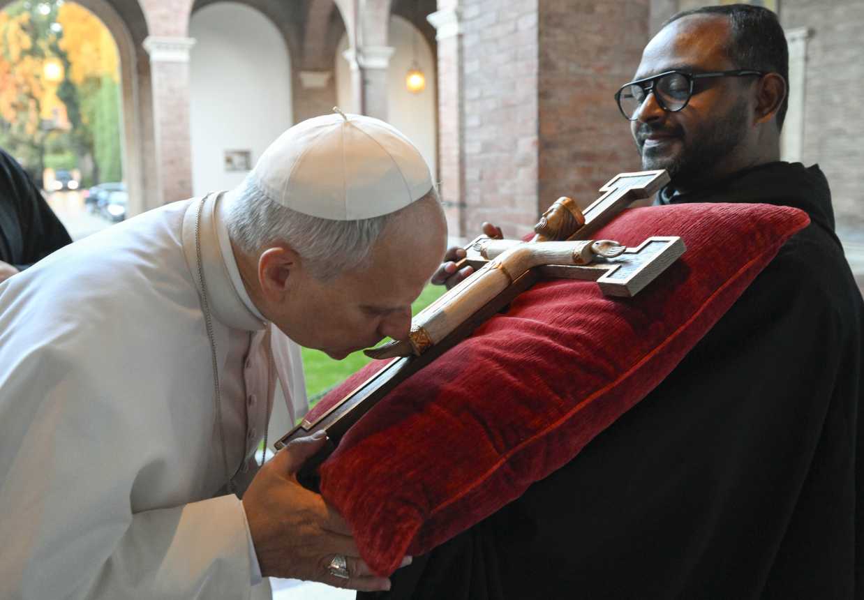 Pope Leo kisses a crucifix
