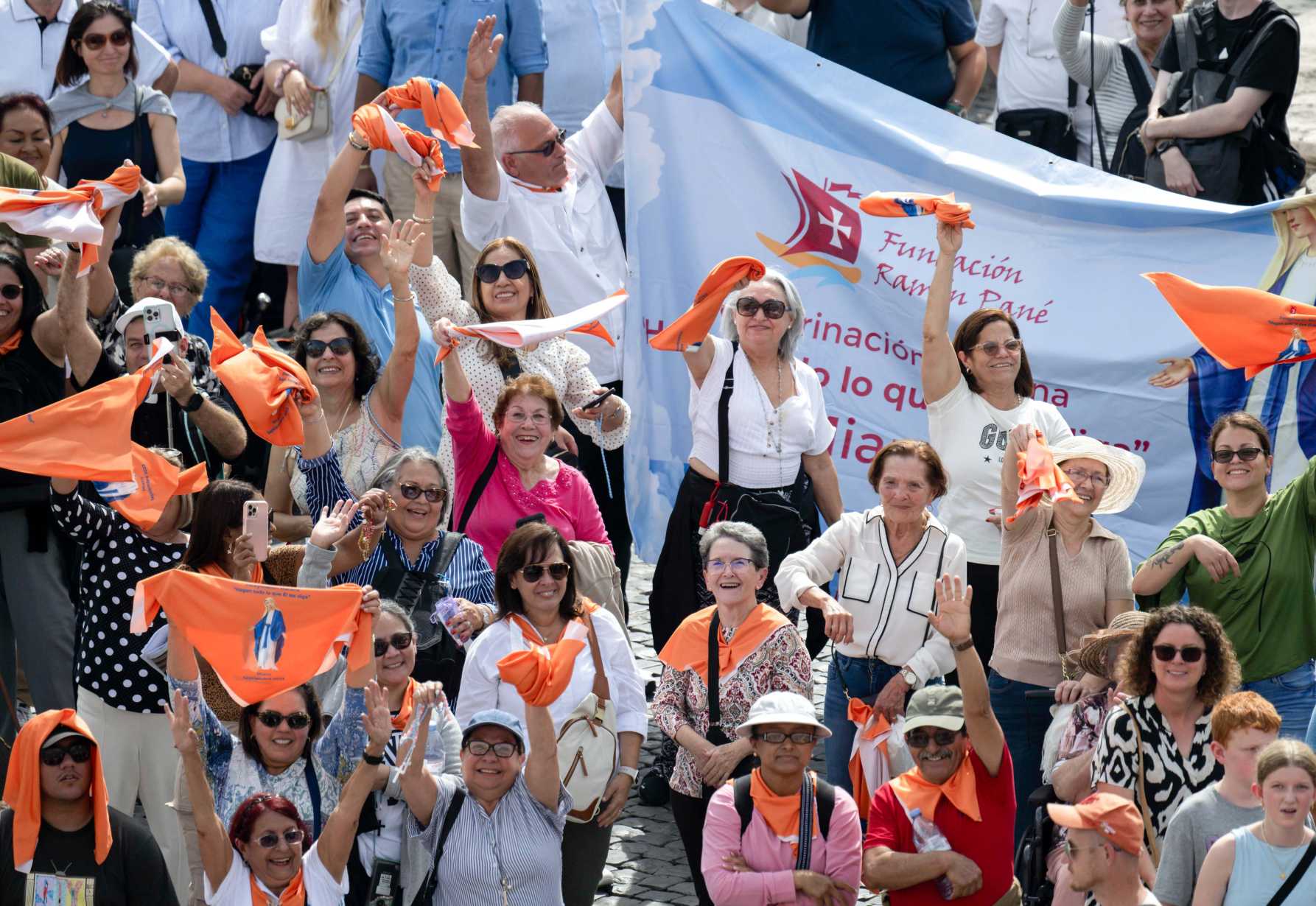 Visitors holding bandanas wave to Pope Francis.