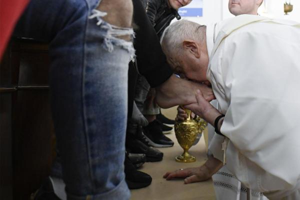 Pope Francis kisses an inmate's foot