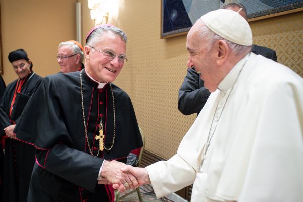 Archbishop Broglio shakes hands with Pope Francis.