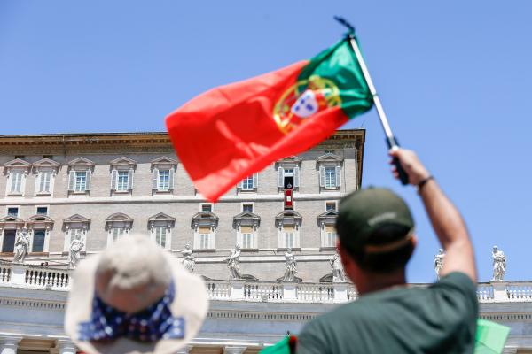 Man waves Portuguese flag in St. Peter's Square.