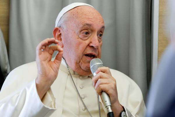 Pope Francis answers a question during an inflight press conference. 