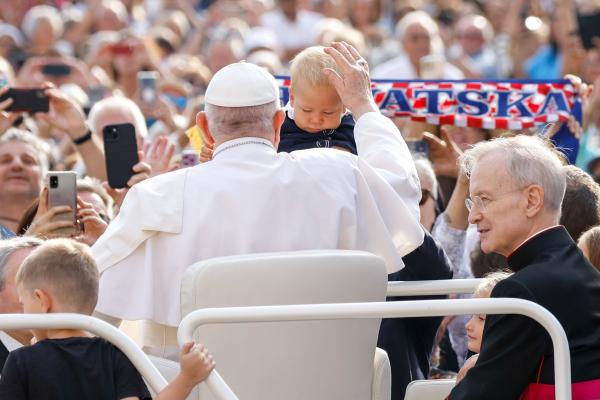 Pope Francis blesses a child while in the popemobile.