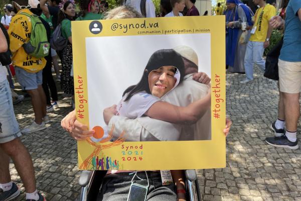 A WYD pilgrim takes photo at Synod booth