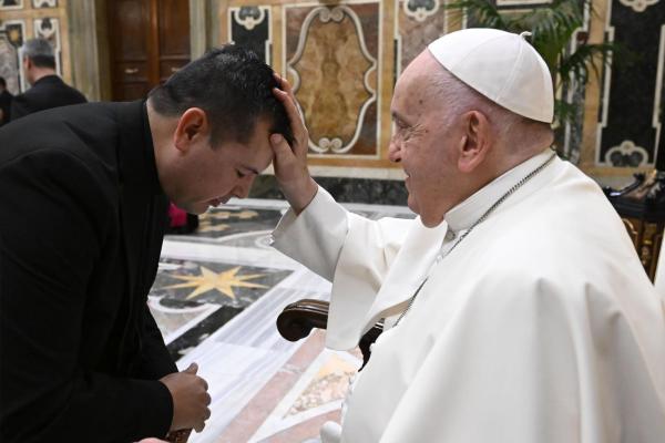 Pope Francis blesses a priest