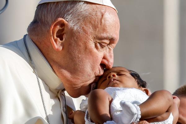 Pope Francis kisses a baby during his general audience.