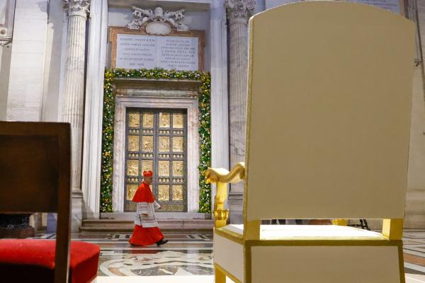 A cardinal walks past the Holy Door of St. Peter's Basilica