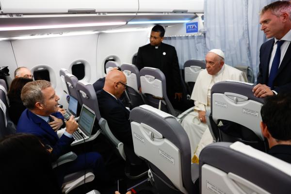 Pope Francis listens to a journalist's question