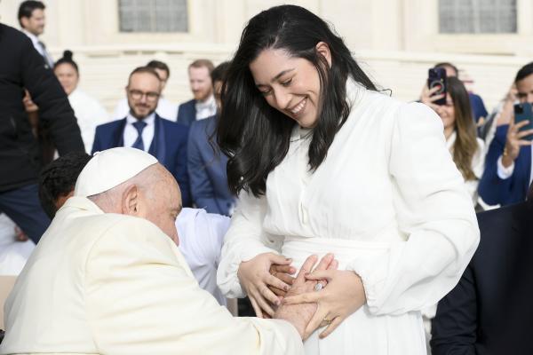 Pope Francis blesses a pregnant woman's unborn child