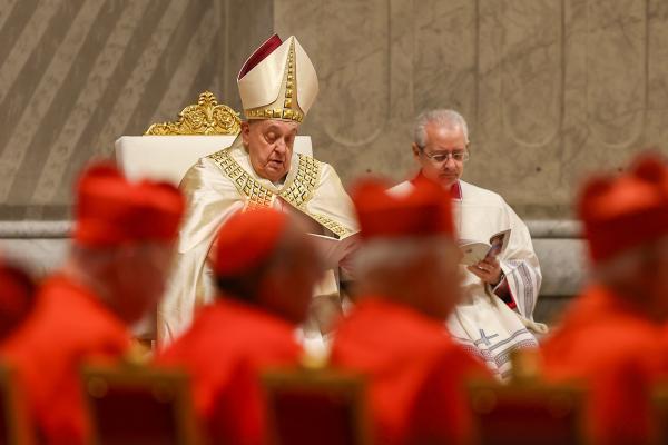 Pope Francis reads from a prayer booklet.