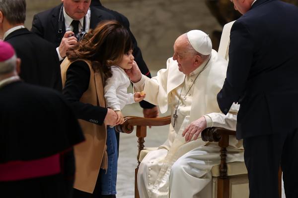 Pope Francis greets a child at the conclusion of his weekly general audience.
