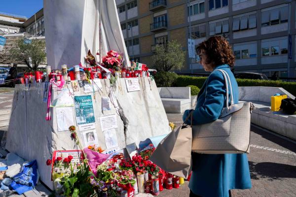 A woman looks at messages for Pope Francis at Gemelli hospital