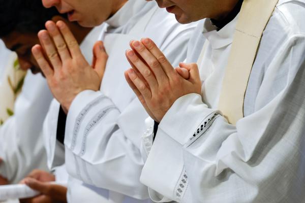 Priests pray during Pope Francis’ Mass.