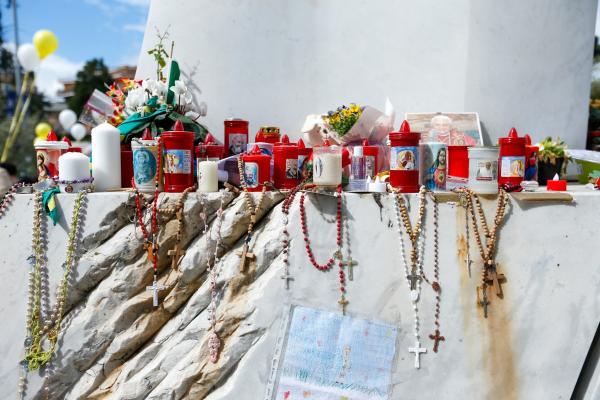 Devotional items are seen at the base of a statue of St. John Paul II outside of Rome's Gemelli hospital.
