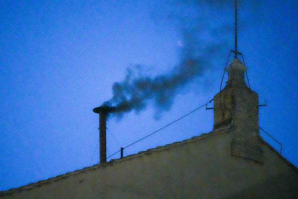 Black smoke billows from the chimney atop the Sistine Chapel.