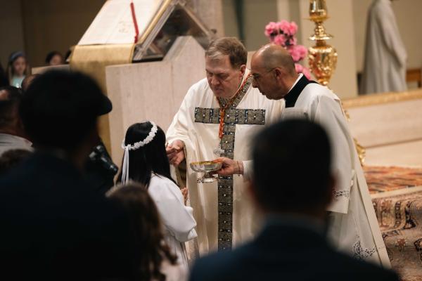 Cardinal Tobin gives a girl her first Communion