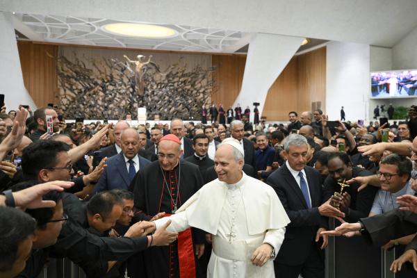 Pope Leo XIV greets clergy members.