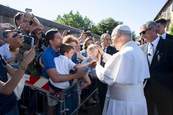 Pope Leo XIV greets children as he arrives in Castel Gandolfo, Italy.
