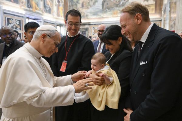 Pope Leo greets a baby and parents