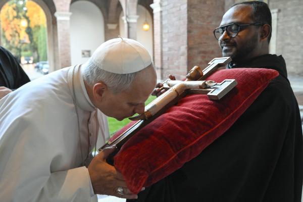 Pope Leo kisses a crucifix