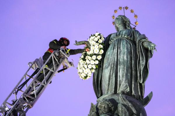 Firefighter places wreath on Marian statue