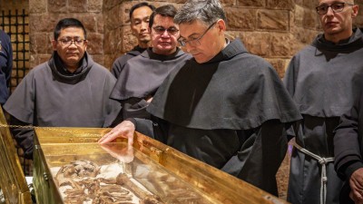Why do the bones of St. Francis draw hundreds of thousands of pilgrims?