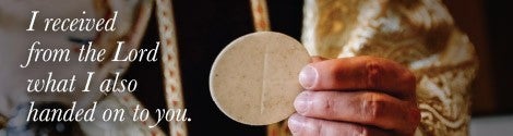 Priest holding a host with text from scripture