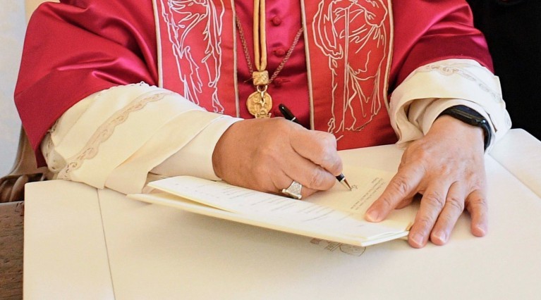 Pope Leo XIV signs a document