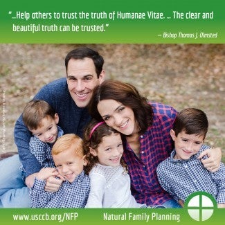 Family with four small children smiling in the grass