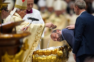 Cardinal Giovanni Battista Re, dean of the College of Cardinals, baptizes a man in St. Peter's Basilica.