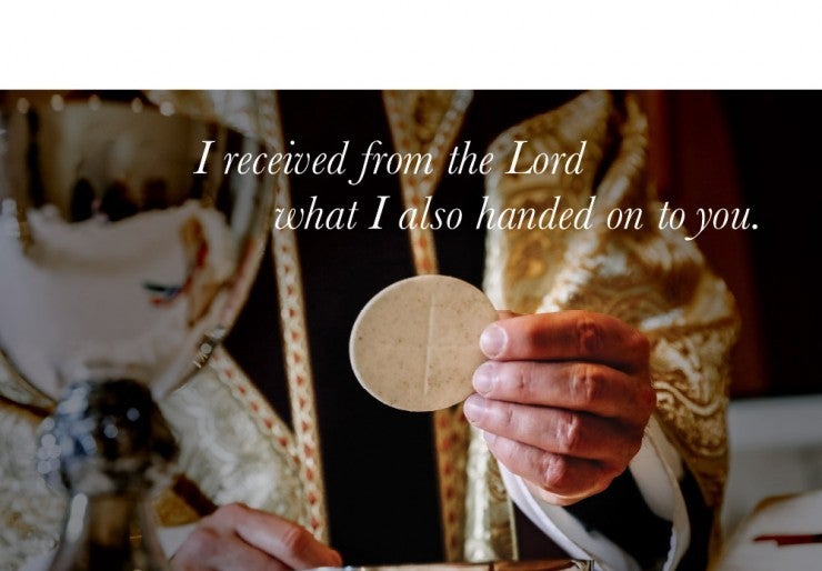 Priest holding a host with text from scripture