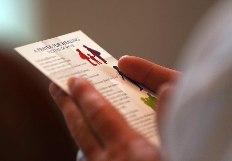 Person holding prayer card