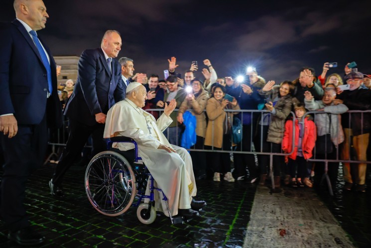 Pope Francis greets people near the Nativity scene in St. Peter's Square.