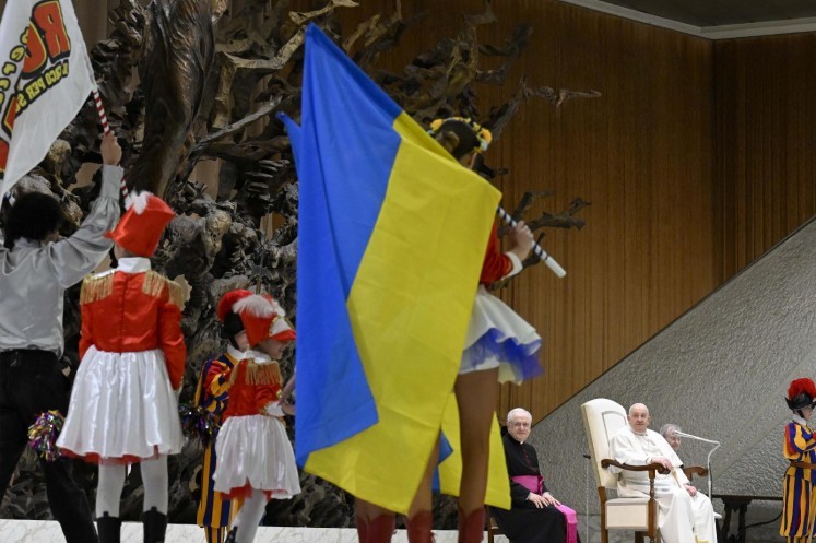 A dancer holds a Ukrainian flag.