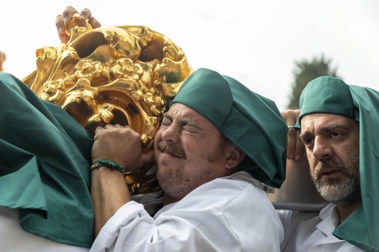 Man helps carry statue of Mary