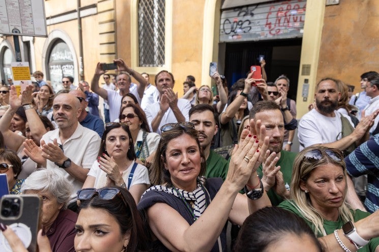 Onlookers applaud as procession passes