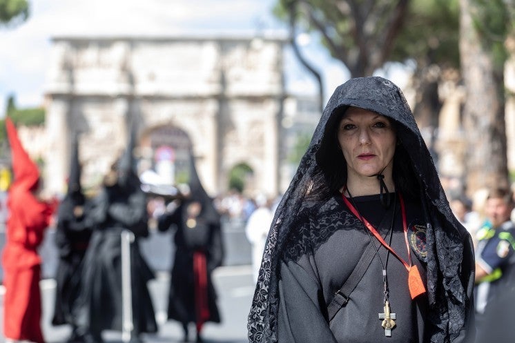 A woman walks in procession in Rome