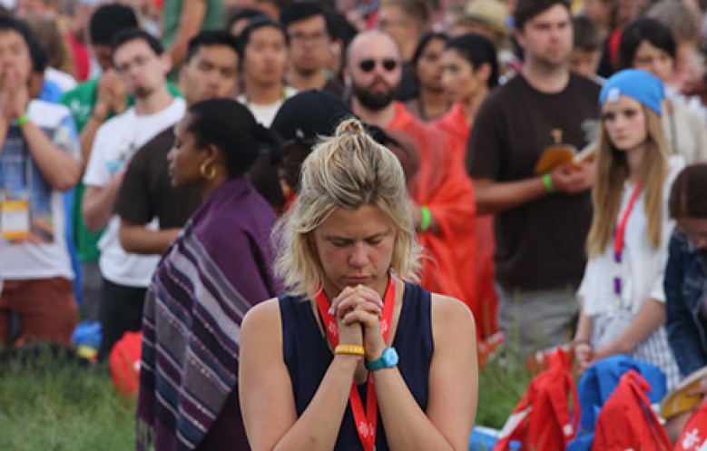 WYD 2016 - A woman prays during the opening Mass. (CNS photo/Bob Roller)